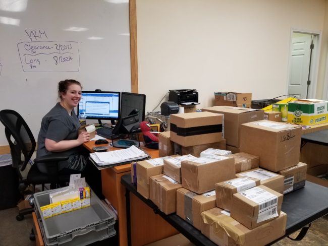 Photograph of young woman working at computer and checking in diabetic test strips