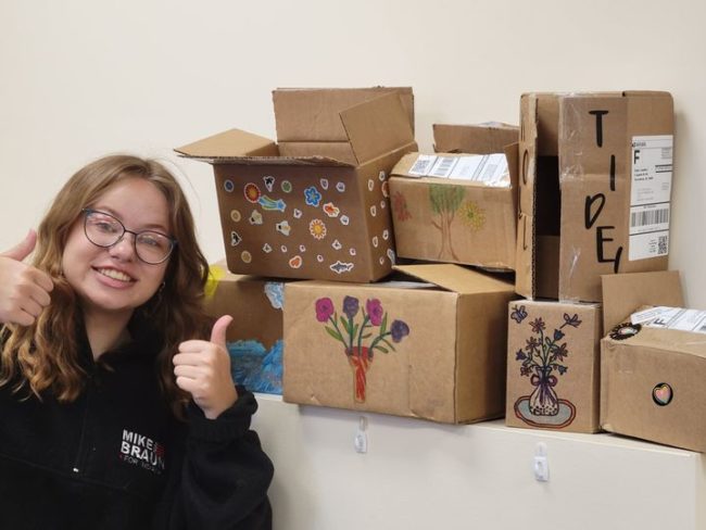 Sell Diabetic Strips and Have Fun! Young Girl with thumbs up near decorated shipping boxes