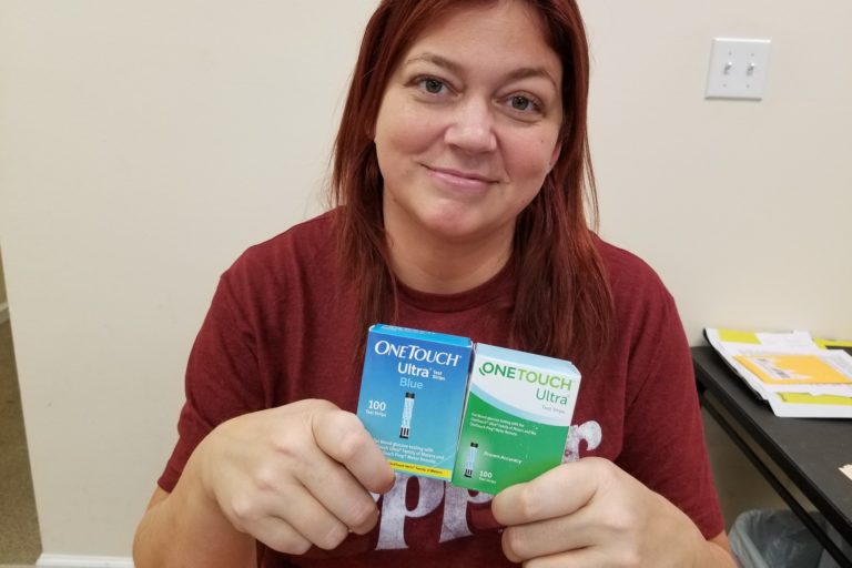 Woman holding two boxes of diabetic test strips